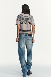 Detail of Nordic geometric knit pattern and red rose floral embroidery on grey short sleeve sweater