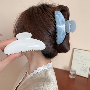 Détail de la grande pince à cheveux fleur en acrylique marbré avec une forte adhérence