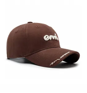 Detailed macro view of the 3D white embroidery letters on the side of a brown cotton cap