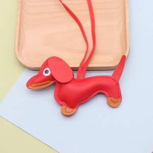 Detail of red faux leather dachshund charm with visible stitching and long lanyard