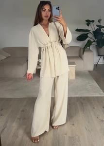Detailed close-up of beige tie-waist long sleeve top and wide-leg trouser set