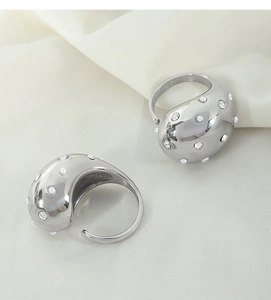 Detailed view of silver C-shaped earrings set with white pearls and sparkling rhinestones