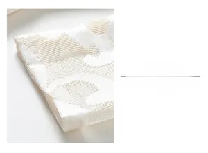 Detail of white lace dress sleeve with intricate hollow-out mesh knit embroidery