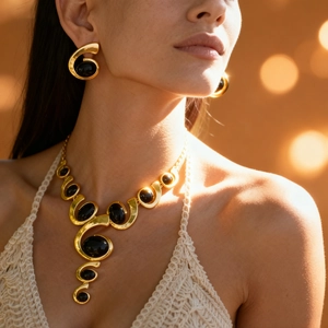 Gros plan d'un ensemble de bijoux vintage en or avec pierres noires ovales sur un mannequin