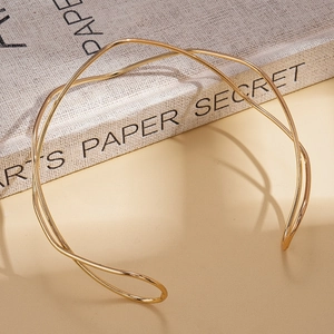 Detail view of a minimalist gold wavy choker with double metallic crossing lines
