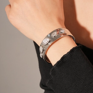 Gros plan du bracelet jonc argenté avec pierres effet marbre et bords ondulés organiques