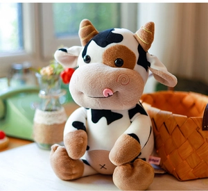 Primer plano de una linda vaca de peluche manchada en un acogedor entorno interior hogareño