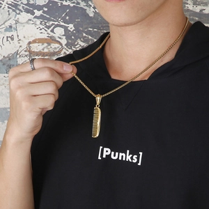Gros plan d'un collier avec pendentif peigne doré porté par un mannequin style urbain