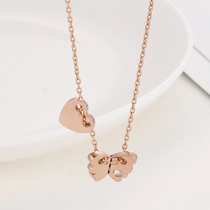 Close-up of rose gold butterfly and heart pendant necklace with sparkling crystal