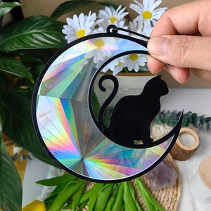 Close-up of rainbow prism moon and black cat suncatcher reflecting vibrant colors