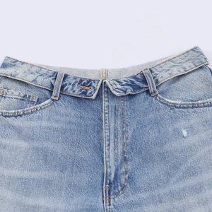 Détail de la taille d'un jean bleu clair avec fermeture à bouton asymétrique unique