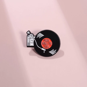 Broche en émail rétro tourne-disque avec citation Music Heals My Soul sur fond rose