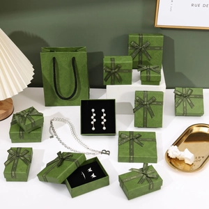 Elegant green floral jewelry box and gift bag set with gold ribbon and pearl necklace