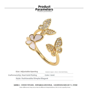 Macro detail of triple butterfly ring in gold plated copper with zircon and enamel inlays