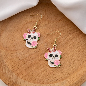 Halloween skull drop earrings with pink roses and red butterflies on a wooden tray