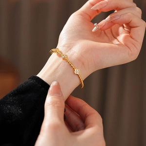 Dettaglio del bracciale a quadrifoglio placcato oro 18k con zirconi bianchi al polso