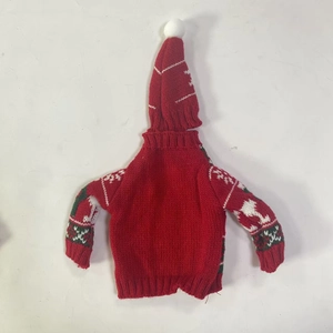 Macro detail of red Christmas knit bottle sweater and matching hat with white snowflakes