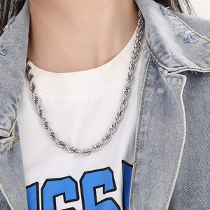 Close-up of a silver stainless steel twist rope chain necklace worn on a casual model
