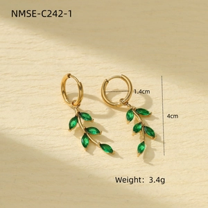 Golden olive leaf earrings with green marquise stones on a minimalist stand