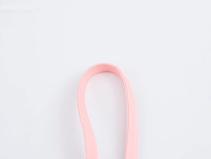 Dettaglio del cinturino in tessuto rosa con cuciture precise su uno sfondo bianco puro