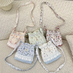 Detailed set of five floral crossbody bags with lace trim on a white plush background