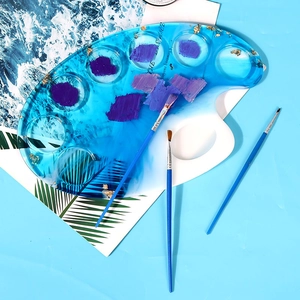 Close-up of ocean-style resin palette with gold foil and three blue art paintbrushes