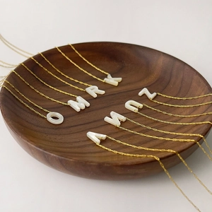 Collier minimaliste en titane doré avec pendentifs alphabet en nacre sur bois