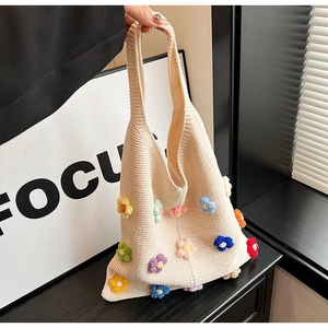 Detail of knit tote bag featuring colorful 3D flowers and soft woven texture