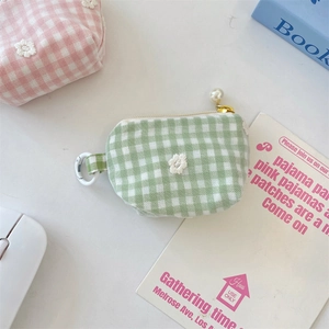Close-up of gingham coin purse with floral embroidery and a decorative pearl zipper