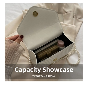 Interior view of white quilted crossbody bag showing storage space for phone and makeup
