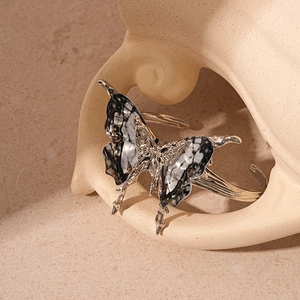 Macro shot of silver butterfly cuff with black and white marble textured resin wings