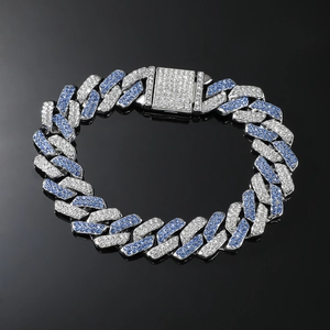 Macro view of Cuban link chain with silver and blue rhinestones on black background