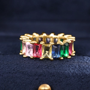 Macro-opname van gouden eternity ring met rechthoekige veelkleurige regenboog edelstenen