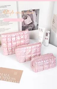 Three-piece set of pink holographic quilted makeup bags in various sizes with zippers