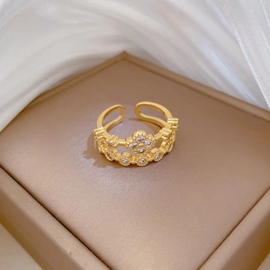 Adjustable gold clover ring with pavé diamonds on a premium jewelry display