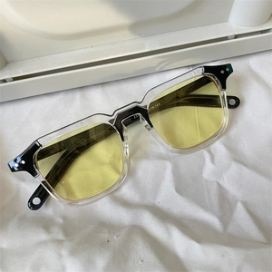Macro detail of yellow tinted sunglasses showing size parameters on a bicolor frame