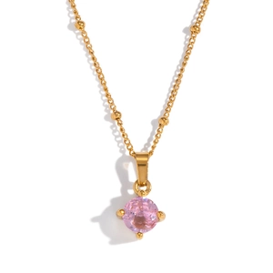 Macro detail of a pink faceted zircon pendant with gold four-prong setting on a chain