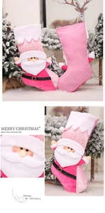 Detail of pink knitted Christmas stocking with plush 3D Santa Claus and fluffy white trim