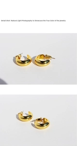 Detail shot of chunky gold-plated C-shaped earrings with a polished metallic finish