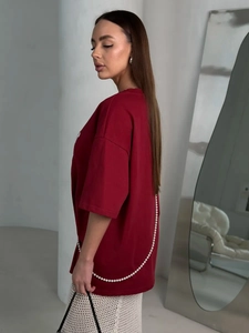Detail of burgundy oversized T-shirt featuring beaded chain accents on the side and back