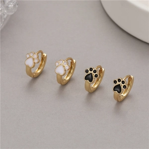 Golden cat paw earrings with black and white enamel details in a minimalist ins style