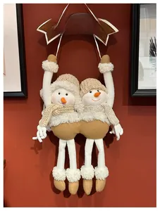 Detail of plush snowmen ornaments with BIENVENIDO banner on a festive red wall