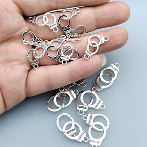 Close-up of alloy handcuff charms with Freedom engraving for DIY jewelry making