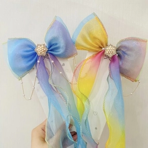 Detailed view of dreamy gradient tulle hair bows with pearls, rhinestones, and gold trim