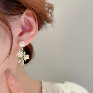 Détail montrant d'élégantes boucles d'oreilles muguet en perles sur un mannequin