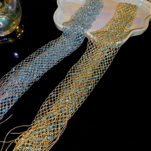 Close-up of metallic mesh necklace with blue beads in gold and silver finish