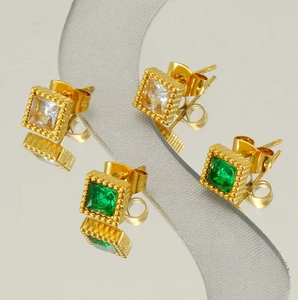 Detail of square zircon stud earrings in gold with white and emerald green gemstones
