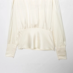 Blouse élégante en satin crème avec nœud au dos et taille plissée pour un look chic