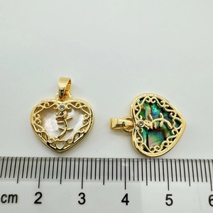Detail of 18K gold-plated heart charms with shell inlays showing size on ruler