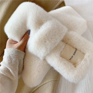 Close-up of fluffy beige faux rabbit fur scarf showing soft texture and brand label